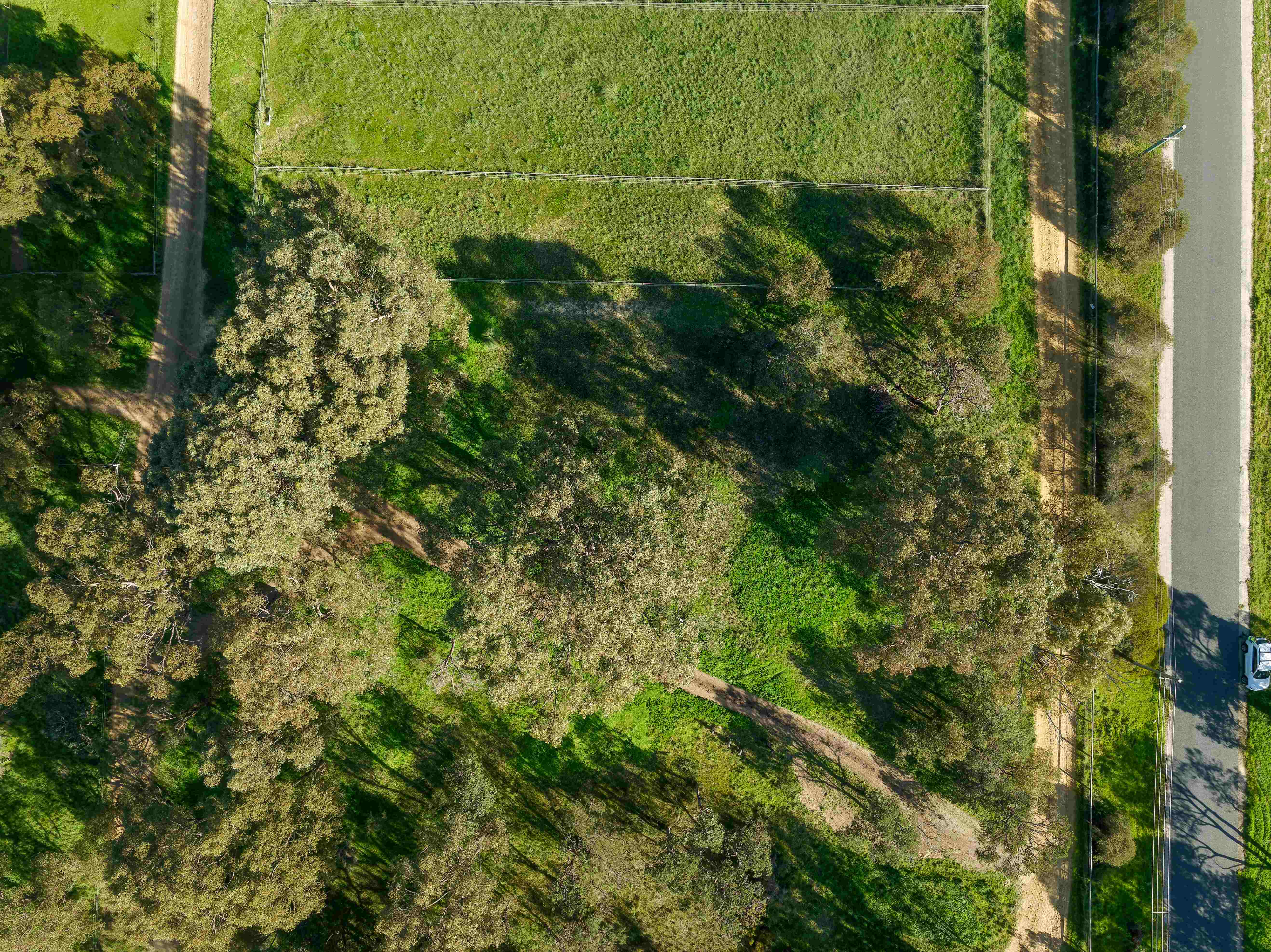 Aerial view of lush greenery, walking trails, and tree canopies at Botania Park in Perth, showcasing the community’s commitment to sustainable development and environmental preservation.
